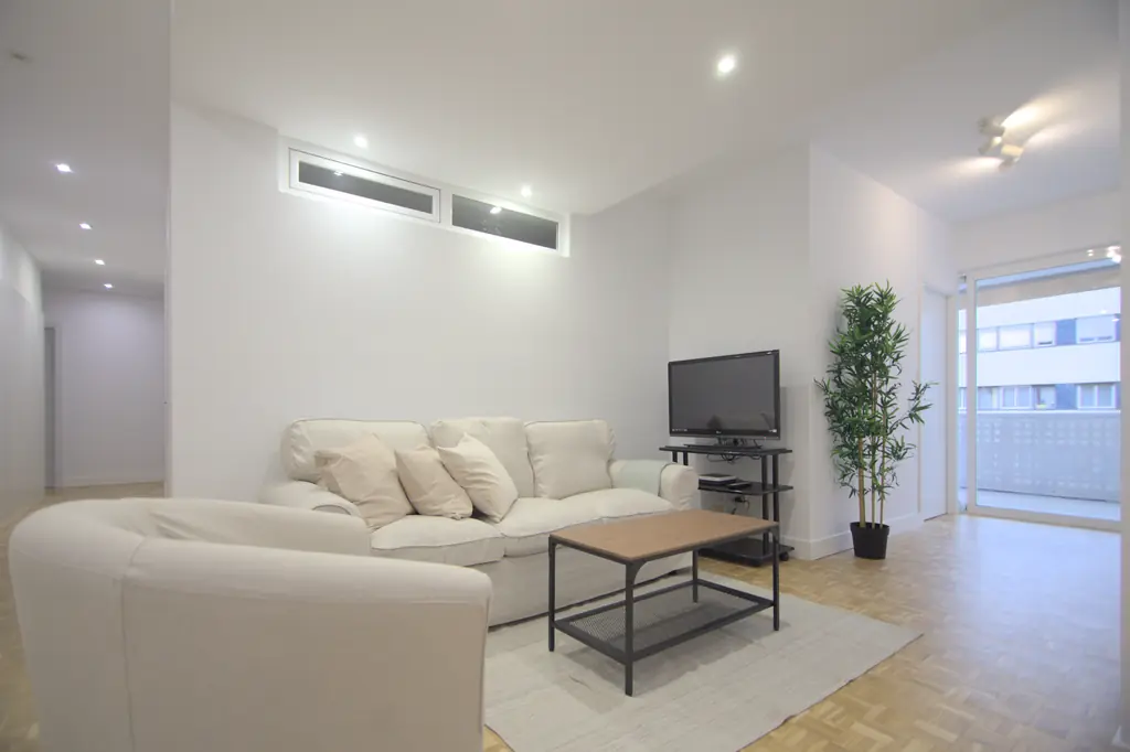 Salón con sofá blanco, butaca y mesa de centro